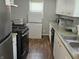Kitchen featuring white cabinets, laminate countertops, oven, and stainless steel refrigerator at 1601 S Biltmore Ave, Muncie, IN 47302