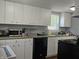 Kitchen includes white cabinets, laminate countertops, dishwasher, and a sink at 1601 S Biltmore Ave, Muncie, IN 47302