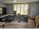 Living room includes large window, beige curtains, brown sofa, and a patterned rug at 1601 S Biltmore Ave, Muncie, IN 47302