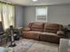 Living room features a large brown sofa, area rug, window with blinds at 1601 S Biltmore Ave, Muncie, IN 47302