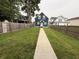 Spacious backyard with a well-maintained lawn enclosed by a wooden fence, accessible by a long sidewalk at 1720 Rembrandt St, Indianapolis, IN 46202