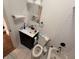 Bathroom with dark vanity, white subway tile, and white toilet and tub at 1720 Rembrandt St, Indianapolis, IN 46202