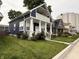 A charming two-story home featuring a covered porch, white columns, and green lawn, plus neighboring houses at 1720 Rembrandt St, Indianapolis, IN 46202