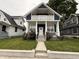 Charming two-story home featuring a covered front porch, white columns, and a well-maintained lawn with flowers at 1720 Rembrandt St, Indianapolis, IN 46202