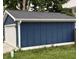Garage featuring a blue siding, a white door, and trim, providing ample parking and storage space at 1720 Rembrandt St, Indianapolis, IN 46202