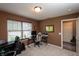 Bright bedroom with a desk and large window that has wood-toned blinds, next to an open doorway at 1792 Persimmon Grove Dr, Indianapolis, IN 46234