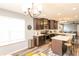 This kitchen features dark cabinets, stainless steel appliances, an island with seating, and wood-look flooring at 1792 Persimmon Grove Dr, Indianapolis, IN 46234