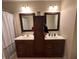 Bathroom featuring a double vanity with dark wood cabinets and framed mirrors at 19409 Mimosa Ct, Noblesville, IN 46060