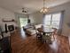 Open-concept living room with a fireplace, wood floors, and sliding glass door to the backyard at 19409 Mimosa Ct, Noblesville, IN 46060