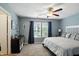 The main bedroom features a ceiling fan, dresser, and large window with beautiful curtains at 19433 Tradewinds Dr, Noblesville, IN 46062
