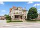 Stately stone home featuring a covered front porch, manicured lawn and mature shade trees at 2105 N Meridian St # 203, Indianapolis, IN 46202