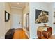 Inviting hallway with warm wood floors, bench seat, console table and art at 2105 N Meridian St # 203, Indianapolis, IN 46202