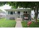 Charming single-story home with a cozy front porch and swing, nestled under the shade of a mature tree at 219 N 9Th Ave, Beech Grove, IN 46107