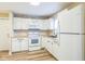 Efficient kitchen with white cabinets, appliances, and wood-look flooring at 2359 N Gale St, Indianapolis, IN 46218