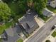 This aerial view showcases a home with a dark roof, complemented by lush greenery and an inviting outdoor deck space at 251 North St, Danville, IN 46122
