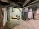 Unfinished basement features exposed pipes, brick foundation, and utilities at 251 North St, Danville, IN 46122