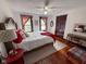 Comfortable bedroom boasts a bed with red blanket, pillows, patterned carpet and natural light from large windows at 251 North St, Danville, IN 46122