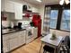 Well-lit kitchen features white cabinets, black countertops and charming retro red appliances at 251 North St, Danville, IN 46122