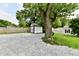 Spacious backyard with gravel area, shed, and mature trees providing a serene outdoor setting at 2801 E Southport Rd, Indianapolis, IN 46227