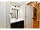 Modern bathroom with a dark vanity, white sink, and a decorative mirror at 2801 E Southport Rd, Indianapolis, IN 46227