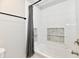 Modern bathroom featuring a tub with stylish tile surround and built-in shelving at 2801 E Southport Rd, Indianapolis, IN 46227