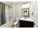 Bathroom with dark vanity, white countertops and sink plus a shower/tub at 2801 E Southport Rd, Indianapolis, IN 46227