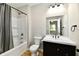Bathroom with a dark vanity, toilet, and shower/tub combo with white tile at 2801 E Southport Rd, Indianapolis, IN 46227