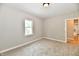 Bedroom with neutral walls, carpet, and bright view into the bathroom at 2801 E Southport Rd, Indianapolis, IN 46227