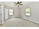 Bedroom featuring plush carpet, ceiling fan, and abundant natural light through two windows at 2801 E Southport Rd, Indianapolis, IN 46227