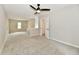 Spacious bedroom with plush carpet and ceiling fan, leading to other rooms at 2801 E Southport Rd, Indianapolis, IN 46227