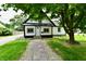 Charming home featuring a paved walkway leading to the front door and is shaded by mature trees at 2801 E Southport Rd, Indianapolis, IN 46227
