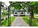 Charming home featuring a paved walkway leading to the front door viewed through an ornate metal garden arch at 2801 E Southport Rd, Indianapolis, IN 46227