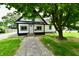 Charming home featuring a paved walkway leading to the front door and is shaded by mature trees at 2801 E Southport Rd, Indianapolis, IN 46227