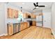 New kitchen with stainless appliances, light wood cabinets, modern lighting and luxury vinyl flooring at 2801 E Southport Rd, Indianapolis, IN 46227