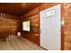 The living room has natural wood walls and a neutral floor and is brightly lit by a large window at 2801 E Southport Rd, Indianapolis, IN 46227