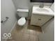 Compact bathroom featuring tiled flooring, a toilet and sink with vanity at 2930 N Rural St, Indianapolis, IN 46218