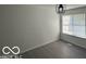 Bright bedroom featuring neutral paint, modern light fixture, luxury vinyl flooring, and large windows at 2930 N Rural St, Indianapolis, IN 46218