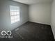 Cozy bedroom featuring a large window for natural light and plush neutral carpeting at 2930 N Rural St, Indianapolis, IN 46218
