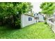 Backyard view featuring the home, detached garage, picket fence, and lush lawn at 313 N 16Th Ave, Beech Grove, IN 46107