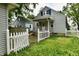 View of the home with a picket fence and lush green grass in the backyard at 313 N 16Th Ave, Beech Grove, IN 46107