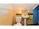 Cozy bathroom with pedestal sink, toilet and wall lighting at 313 N 16Th Ave, Beech Grove, IN 46107