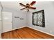 Bedroom with hardwood floors, light gray walls, ceiling fan, and a dinosaur themed curtain at 313 N 16Th Ave, Beech Grove, IN 46107