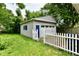 Detached garage with a white door, blue accent door, picket fence, and grass at 313 N 16Th Ave, Beech Grove, IN 46107