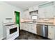 Charming kitchen with tiled floors, white cabinetry, and stainless steel dishwasher at 313 N 16Th Ave, Beech Grove, IN 46107