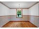 Elegant dining room featuring hardwood floors, chair railing, wallpaper, and a chandelier at 3235 Flintwood Dr, Columbus, IN 47203
