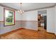 View of the dining room with hardwood floors, wainscoting, chandelier, and a window offering natural light at 3235 Flintwood Dr, Columbus, IN 47203