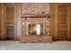 A traditional brick fireplace with glass doors and a wood mantel is flanked by wood paneled walls at 3235 Flintwood Dr, Columbus, IN 47203