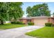 Charming brick ranch home with a well-maintained front yard, mature trees, and a two-car garage at 3235 Flintwood Dr, Columbus, IN 47203