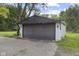 A one-car detached garage with a black door and white siding at 330 S Green St, Brownsburg, IN 46112