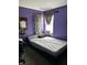 Bedroom featuring a platform bed, window with curtains, and purple walls at 4264 Village Trace Dr, Indianapolis, IN 46254